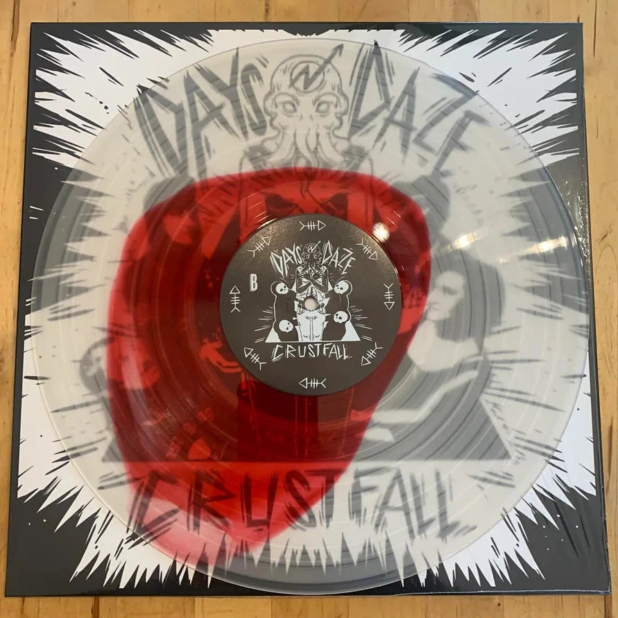 Vinyl record with a red center and black and white cover on a wooden surface